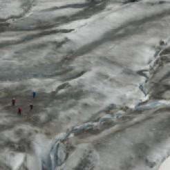 A ribbon of glacial melt, a cluster of ice hikers on Exit Glacier, AK